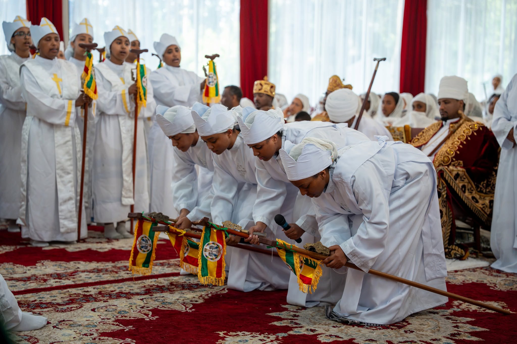 Mezmur Kifil choir members singing and rehearsing in traditional Ethiopian Orthodox attire